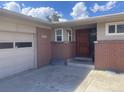 Front view of home, showcasing a wood front door and brick facade at 1515 S Monaco Pkwy, Denver, CO 80224