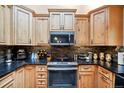 Modern kitchen with wood cabinets, granite countertops, and stainless steel appliances at 6763 Deer Path, Evergreen, CO 80439