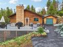 View of the log home's deck, backyard, and attached garage at 6763 Deer Path, Evergreen, CO 80439
