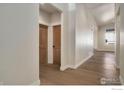 Light-colored hallway with wood floors and doors at 23845 E River Front Dr, Aurora, CO 80019
