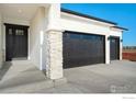 Modern house garage with stone pillars and entry at 23845 E River Front Dr, Aurora, CO 80019