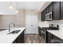 Modern kitchen with dark cabinets, quartz countertops, and stainless steel appliances at 270 S Cherrywood Dr # 103, Lafayette, CO 80026