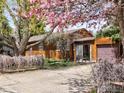 Charming single story home with wood siding, attached garage, and blooming tree at 913 Utica Ave, Boulder, CO 80304