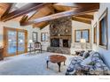 Spacious living room with stone fireplace, high ceilings and access to a deck at 124 Deer Trail Cir, Boulder, CO 80302