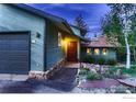 Front exterior view of the home, showcasing a double garage and garden at 124 Deer Trail Cir, Boulder, CO 80302