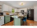 Modern kitchen with green cabinets, granite countertops, and island at 13661 Wrangler Way, Mead, CO 80542