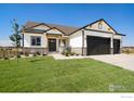 Front view of a two-story house with white siding, dark gray garage doors, and well-manicured lawn at 24113 E 36Th Pl, Aurora, CO 80019