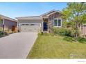 House exterior featuring stone accents and a two-car garage at 944 Prairiestar Dr, Berthoud, CO 80513