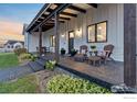 Inviting farmhouse porch with comfortable seating and landscaping at 560 Talons Reach Run, Berthoud, CO 80513