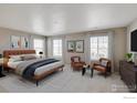 Main bedroom with plush carpeting and two accent chairs at 1847 Pinnacle Ave, Lochbuie, CO 80603