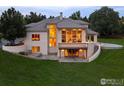 Luxury home with a deck, stonework, and landscaping at dusk at 160 Ponderosa Dr, Boulder, CO 80303