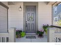 Inviting front door entrance with potted plants and a welcome mat at 2423 Whistler Dr, Longmont, CO 80504