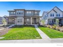 Two story home with front porch and landscaped yard at 2423 Whistler Dr, Longmont, CO 80504