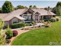 Ranch-style home with a large front yard, expansive driveway and mature trees at 385 Baxter Farm Ln, Erie, CO 80516