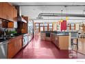 Modern kitchen with stainless steel appliances and red floor at 2245 Blake St # L M N, Denver, CO 80205