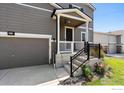 Front entrance with stairs, railing, and landscaping at 6112 Black Mesa Rd, Frederick, CO 80516