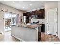 Modern kitchen with island, stainless steel appliances, and hardwood floors at 6112 Black Mesa Rd, Frederick, CO 80516