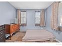 Bedroom with a low platform bed, dresser, and two windows at 11043 Nome St, Commerce City, CO 80640