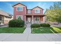 Two-story red brick home with a landscaped lawn and walkway at 11043 Nome St, Commerce City, CO 80640