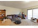 Living room with sofa, coffee table, and access to patio at 8047 Wolff St # F, Westminster, CO 80031