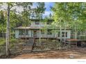 Two-story home with wood deck and steps leading to entrance at 11957 Brook Rd, Golden, CO 80403