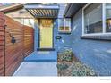 Front entrance with modern yellow door and wood fence at 3877 Utica St, Denver, CO 80212