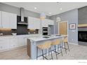 Modern kitchen with white cabinets, island, stainless steel appliances, and gray backsplash at 751 W Grange Ct # B, Longmont, CO 80503