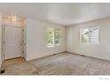 Bright living room with neutral carpeting and large windows at 470 Grey Swallow St, Brighton, CO 80601