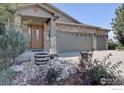 House exterior with stone and siding, three-car garage, and landscaping at 2690 Forsythia Ct, Erie, CO 80516