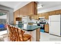 Kitchen with wood cabinets, green countertops, and breakfast bar at 2213 Emery St # C, Longmont, CO 80501