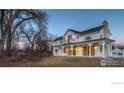 Two-story farmhouse style home with a large porch at 22 Parkstone Ct, Berthoud, CO 80513