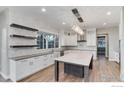 Modern kitchen with white cabinets, a large island, and floating shelves at 22 Parkstone Ct, Berthoud, CO 80513