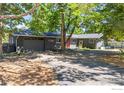 Modern home exterior with gray siding, orange door, and driveway at 7705 Baseline Rd, Boulder, CO 80303