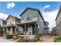 Front view of a charming two-story house with a welcoming porch and landscaping at 1135 Hummingbird Cir, Longmont, CO 80501