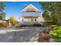 Charming two-story home with a large tree in front and a spacious lawn at 1110 Hover St, Longmont, CO 80501