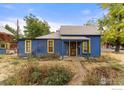 Charming blue house with yellow trim and a spacious front yard at 1860 23Rd St, Boulder, CO 80302