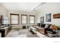 Open living area with exposed brick, large windows, and stylish furnishings at 117 Elati St # 3, Denver, CO 80223