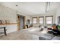 Spacious living room with exposed brick, large windows, and a comfy leather couch at 117 Elati St # 3, Denver, CO 80223