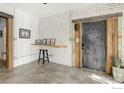 Modern entryway with exposed brick, polished concrete floors, and rustic wood accents at 117 Elati St # 3, Denver, CO 80223