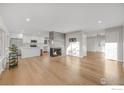 Open living space featuring hardwood floors, a fireplace, and kitchen island at 3955 S Uinta St, Denver, CO 80237