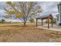 Backyard with pergola and patio, overlooking a large open space at 18715 Wagon Trl, Mead, CO 80542