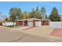 Red brick ranch house with a large yard and a white fence at 1211 16Th Ave, Longmont, CO 80501