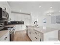 Modern kitchen with white cabinets and quartz countertops at 2774 Enamorado Ln, Brighton, CO 80601