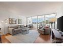 Spacious living room with hardwood floors, large windows, and access to a balcony at 1850 Folsom St # 204, Boulder, CO 80302