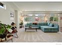 Spacious living room featuring a teal sectional sofa and large windows at 185 Pipit Lake Way, Erie, CO 80516