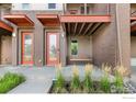 Modern townhome exterior with orange accents and a porch swing at 10334 E 29Th Dr, Denver, CO 80238