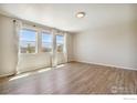 Spacious bedroom with hardwood floors and large windows offering natural light at 1216 Westport Ave, Berthoud, CO 80513