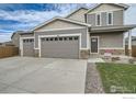 Two-story house with a three-car garage, front yard, and walkway at 186 Bird Way, Lochbuie, CO 80603