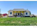 Ranch style home with covered porch and well-manicured lawn at 10691 County Road 23, Fort Lupton, CO 80621