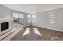 Bright living room with hardwood floors, fireplace, and sliding glass door to backyard at 1815 Chaffee Crest Dr, Berthoud, CO 80513